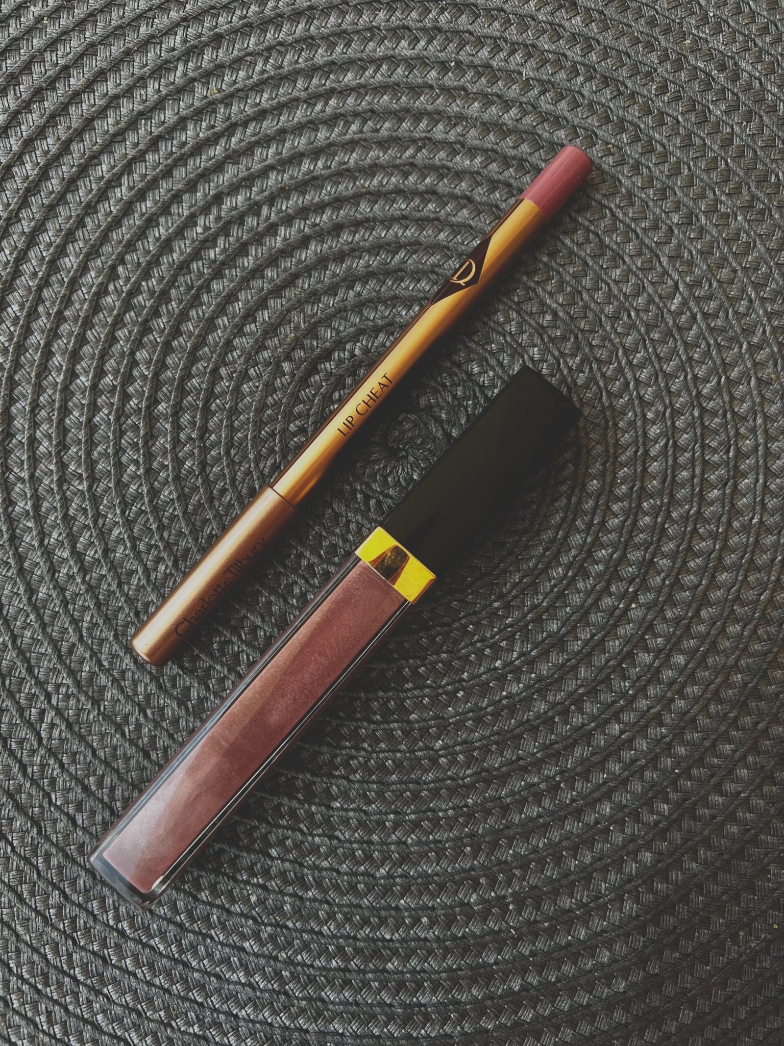 pexels photo 27491259 27491259 Flat lay of lipstick and lip liner on a dark textured mat, perfect for beauty displays.